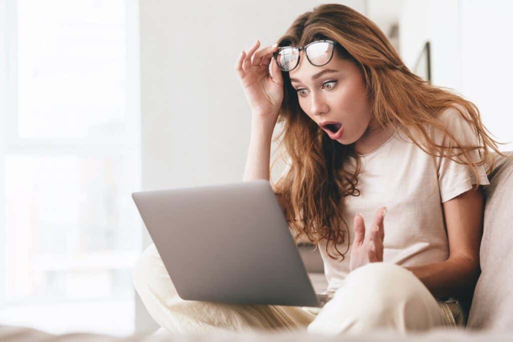 mujer mirando sorprendida por lo que ve en su computadora